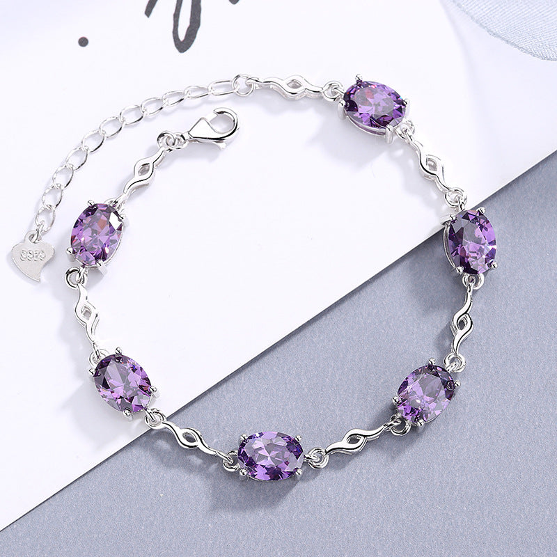 Damen Armband mit lila Schmucksteinen und elegantem Wellenmuster Shop Nory