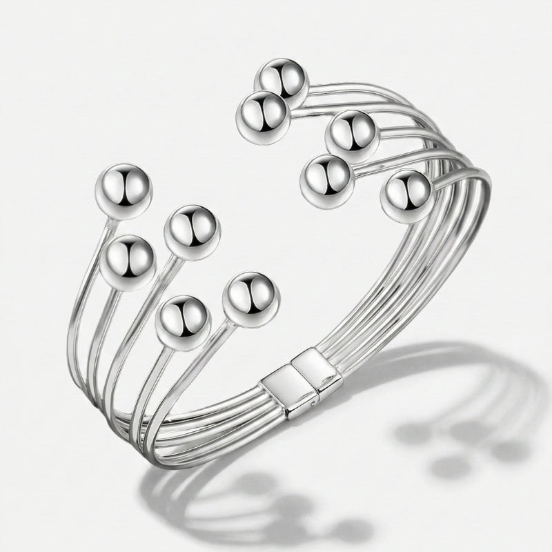 Damenarmband mit mehreren glatten Metallreihen und polierten Kugelenden, in Gold- oder Silberoptik am Handgelenk und in Detailansicht dargestellt