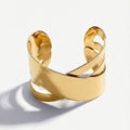 Goldfarbenes Damen-Armreif-Armband mit breitem Überkreuz-Design, getragen am Handgelenk und in Detailansicht dargestellt