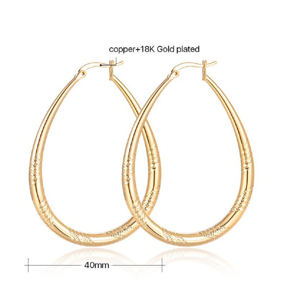 Große glänzende vergoldete ovale geschnitzte Cut-Hoops-Ohrringe | Shop Nory