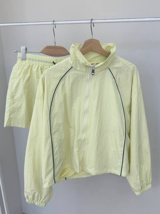 Damen gekürztes Windjacke-Set mit Stehkragen, kontrastierender Paspelierung und elastischer kurzer Freizeit-Hose Shop Nory