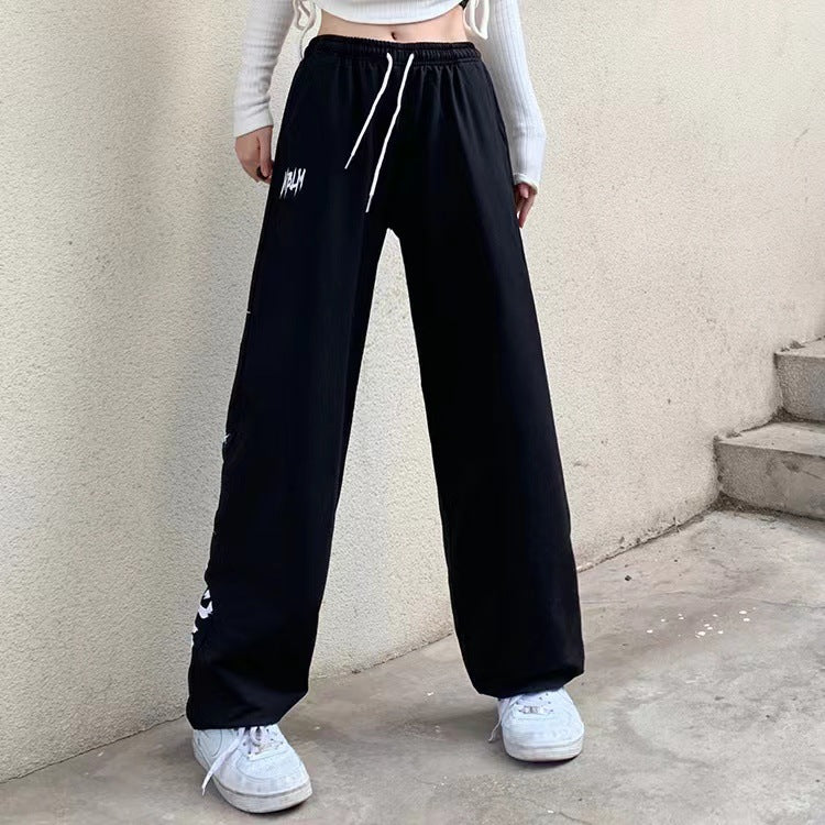 Damen nan locker geschnittene Wide‑Leg Jogginghose mit hohem Bund und markantem Seitenschriftzug Shop Nory