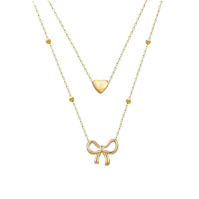 Damen Halskette mit doppellagigem Design und zarten Herz- und Schleifenanhängern Shop Nory