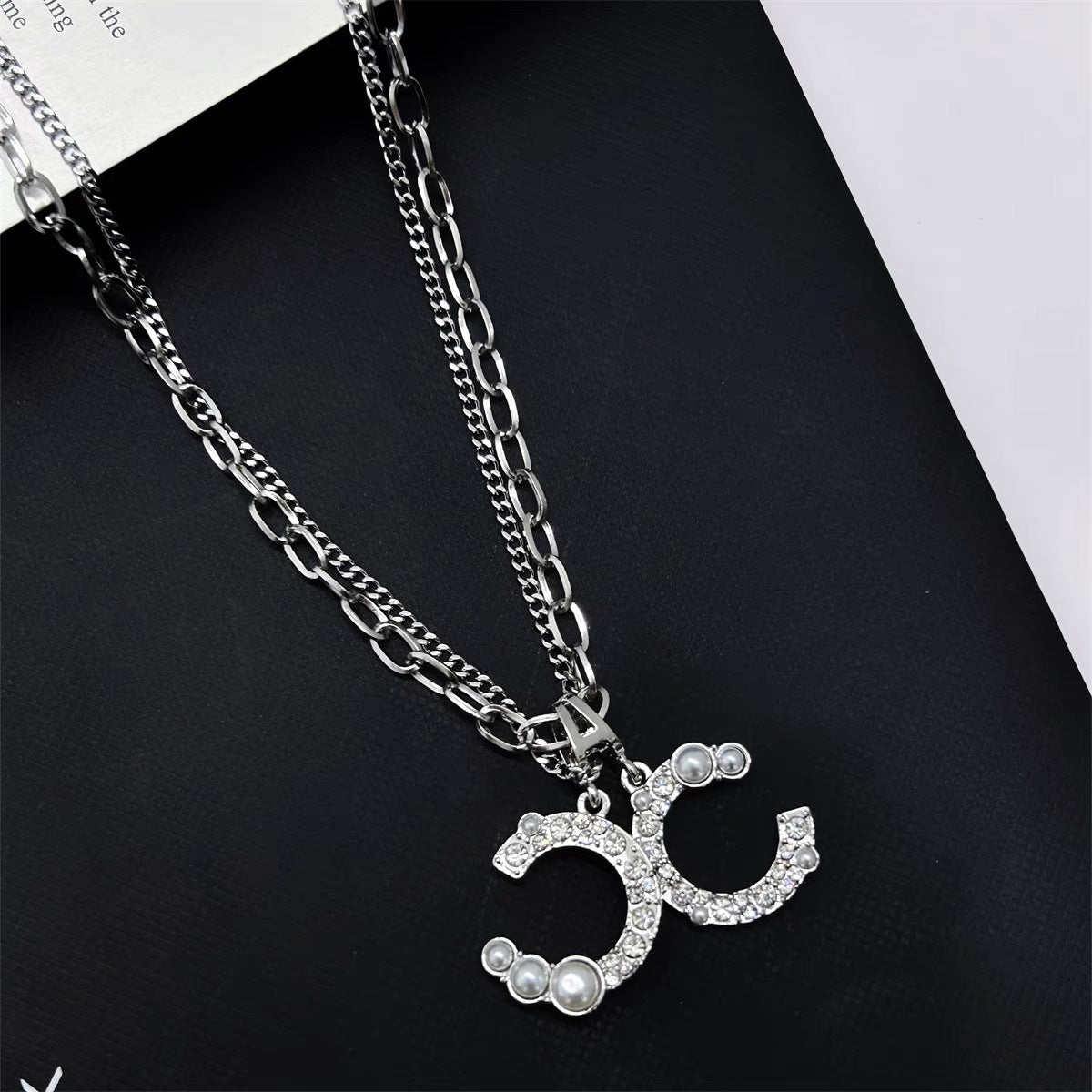 Damen Kette mit funkelndem Logoanhänger und Perlendetails Shop Nory