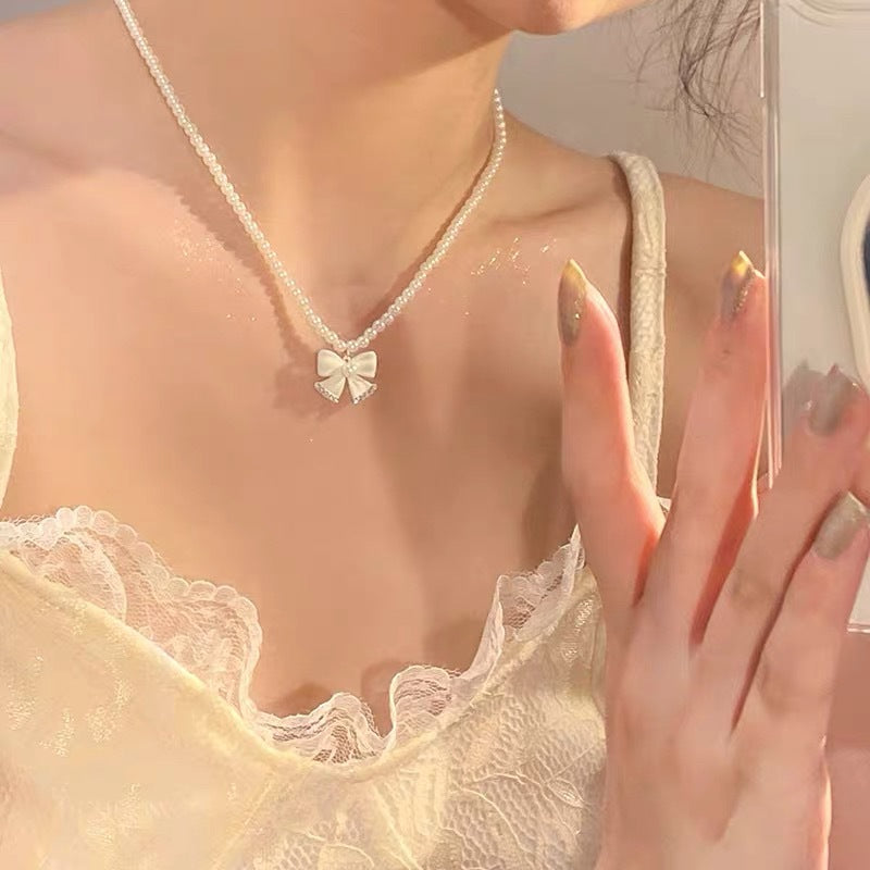 Damen Halskette mit elegantem Perlenband und filigranem Schleifenanhänger Shop Nory