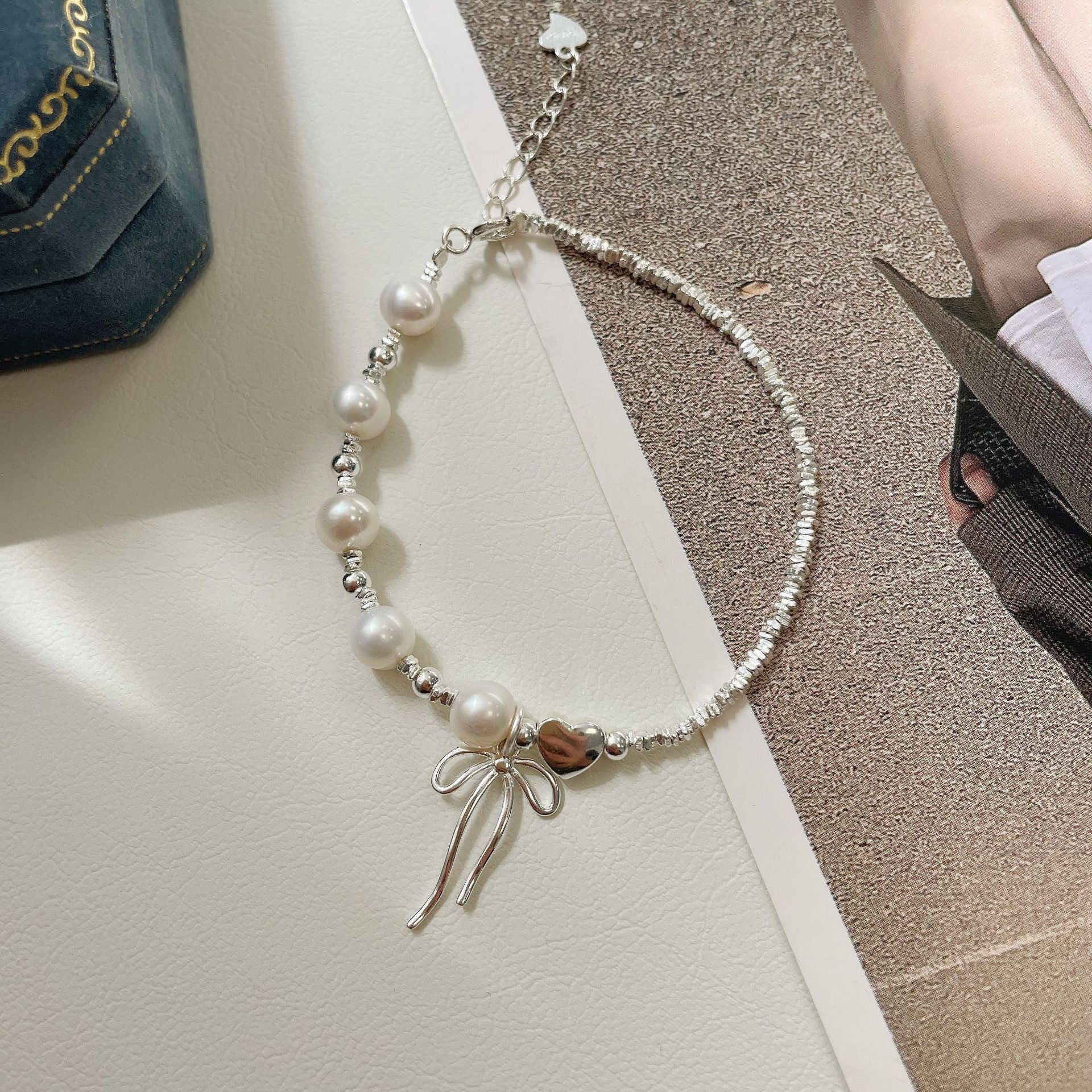 Damen Schmuckarmband mit filigranem Schleifenanhänger und hochwertigen Perlen Shop Nory