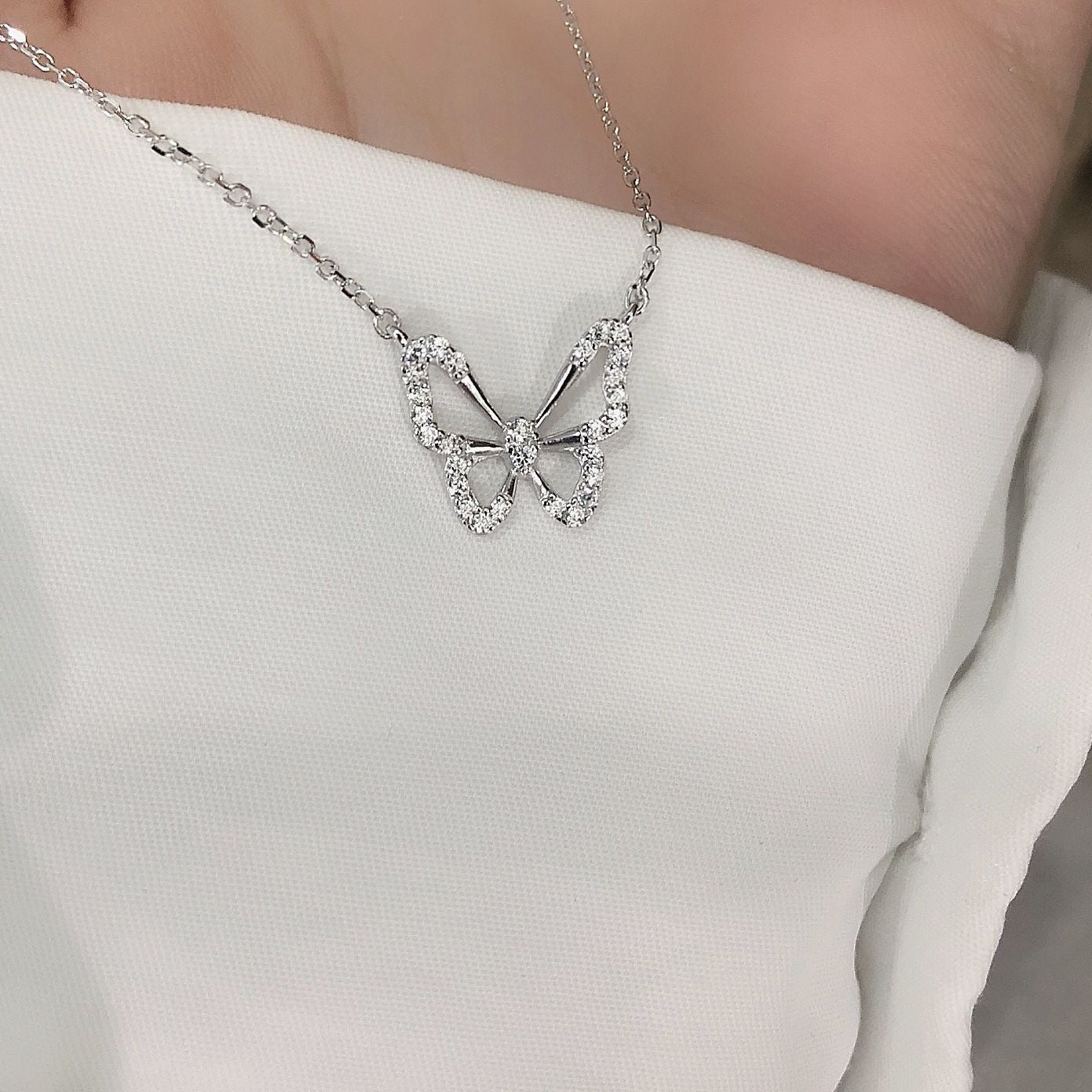 Damen Halskette mit filigranem Schmetterlingsanhänger und funkelnden Kristallen Shop Nory