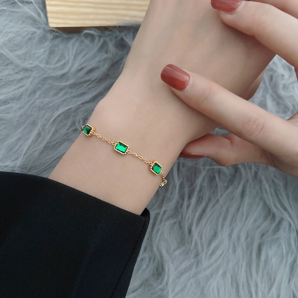 Damen Armband mit funkelnden grünen Steinen und hochwertiger Vergoldung Shop Nory