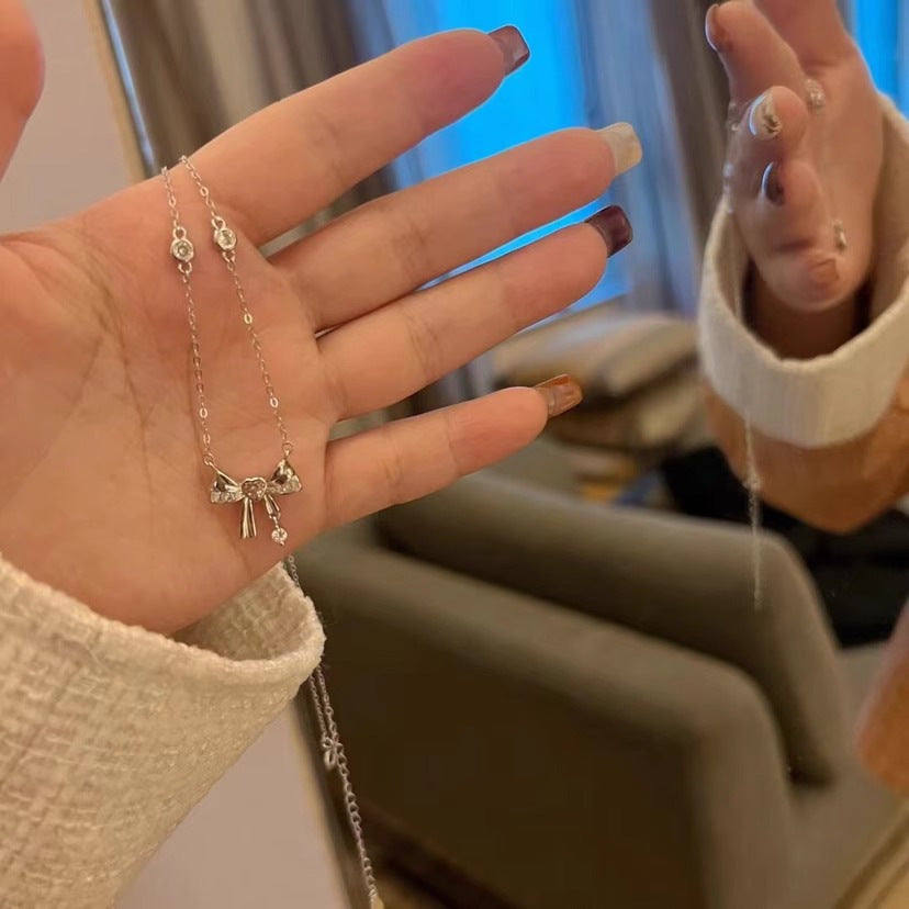 Damen Halskette mit elegantem Schleifenanhänger und funkelnden Kristallakzenten Shop Nory
