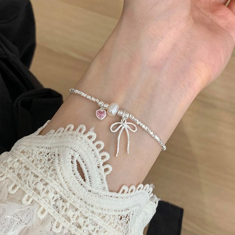 Damen Armreif mit Herz-, Perlen- und Schleifenanhänger Shop Nory