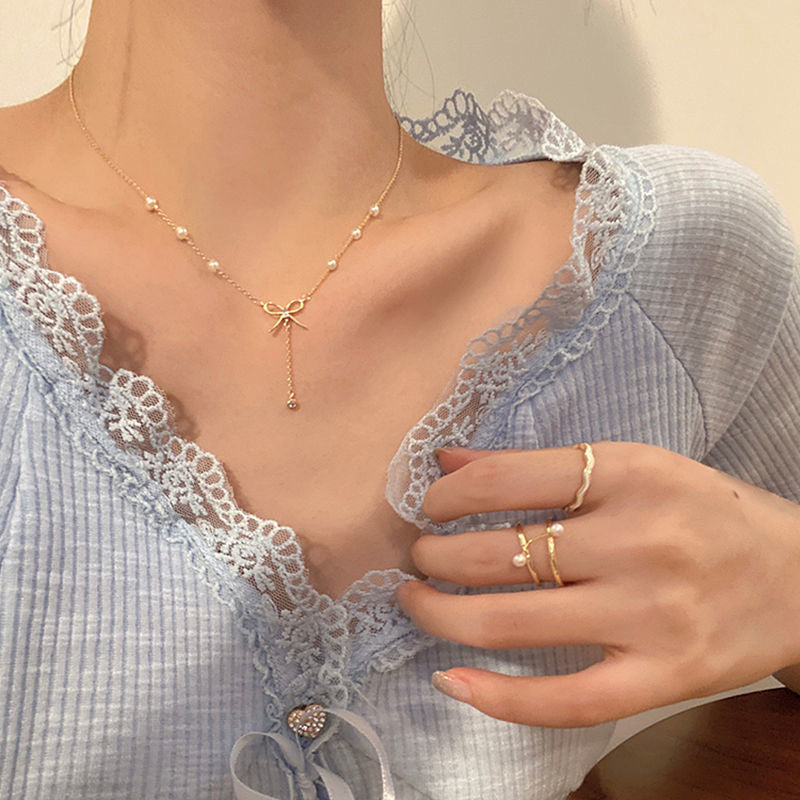 Damen Kette mit zartem Schleifenanhänger und eleganten Perlendetails Shop Nory