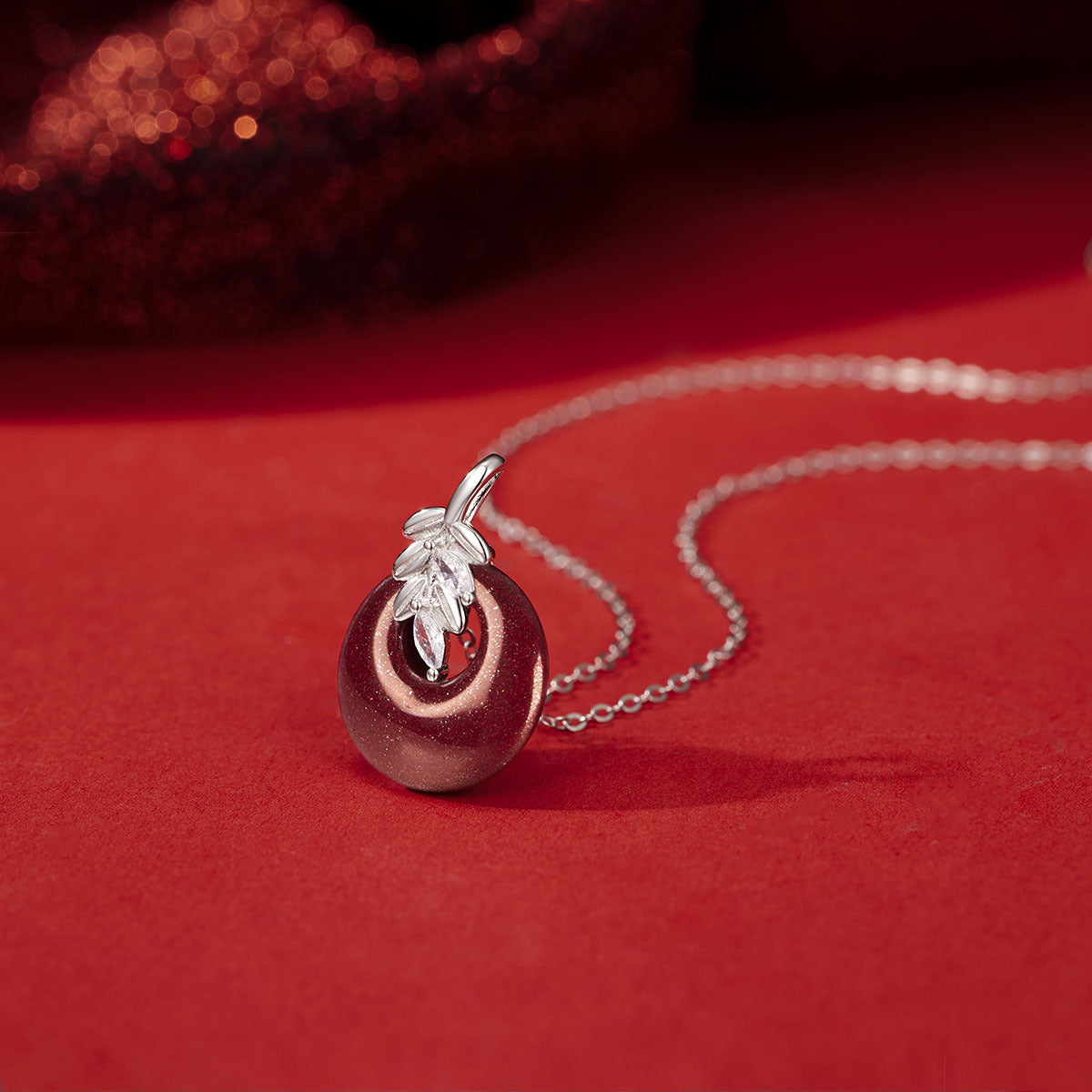 Damen Halskette mit kunstvollem runden Anhänger aus rotem Halbedelstein und goldenen Blätterdetails Shop Nory