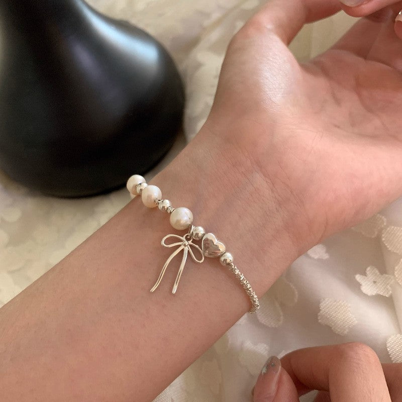 Damen Schmuckarmband mit filigranem Schleifenanhänger und hochwertigen Perlen Shop Nory