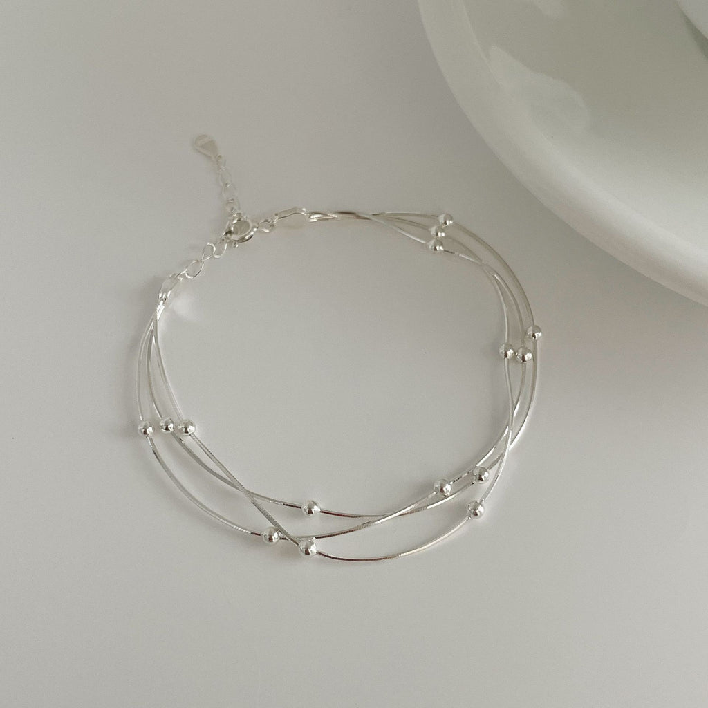 Damen stilvolles Armband mit geschwungenem Design und glänzenden Perlen Shop Nory