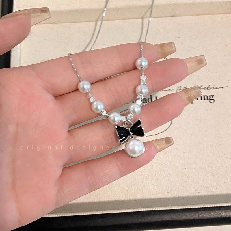 Damen Halskette mit verspieltem Schleifenanhänger und eleganten Perlen Shop Nory