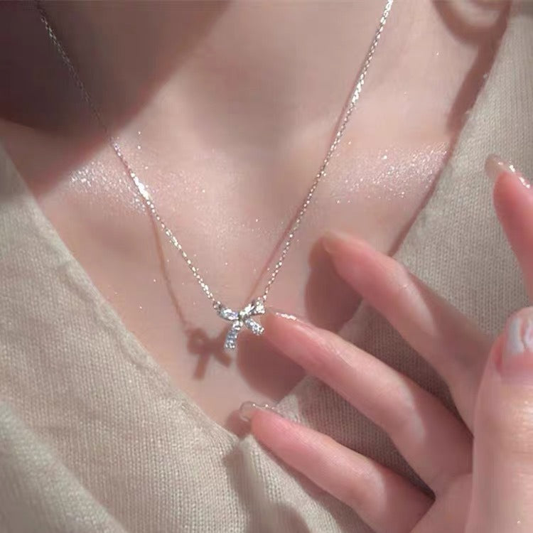Damen Halskette mit funkelndem Schleifenanhänger und edlem Design Shop Nory