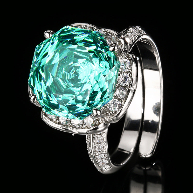 Luxuriöser Cocktailring aus Sterlingsilber mit Halo, großem facettiertem synthetischen Edelstein und Pavé-Band