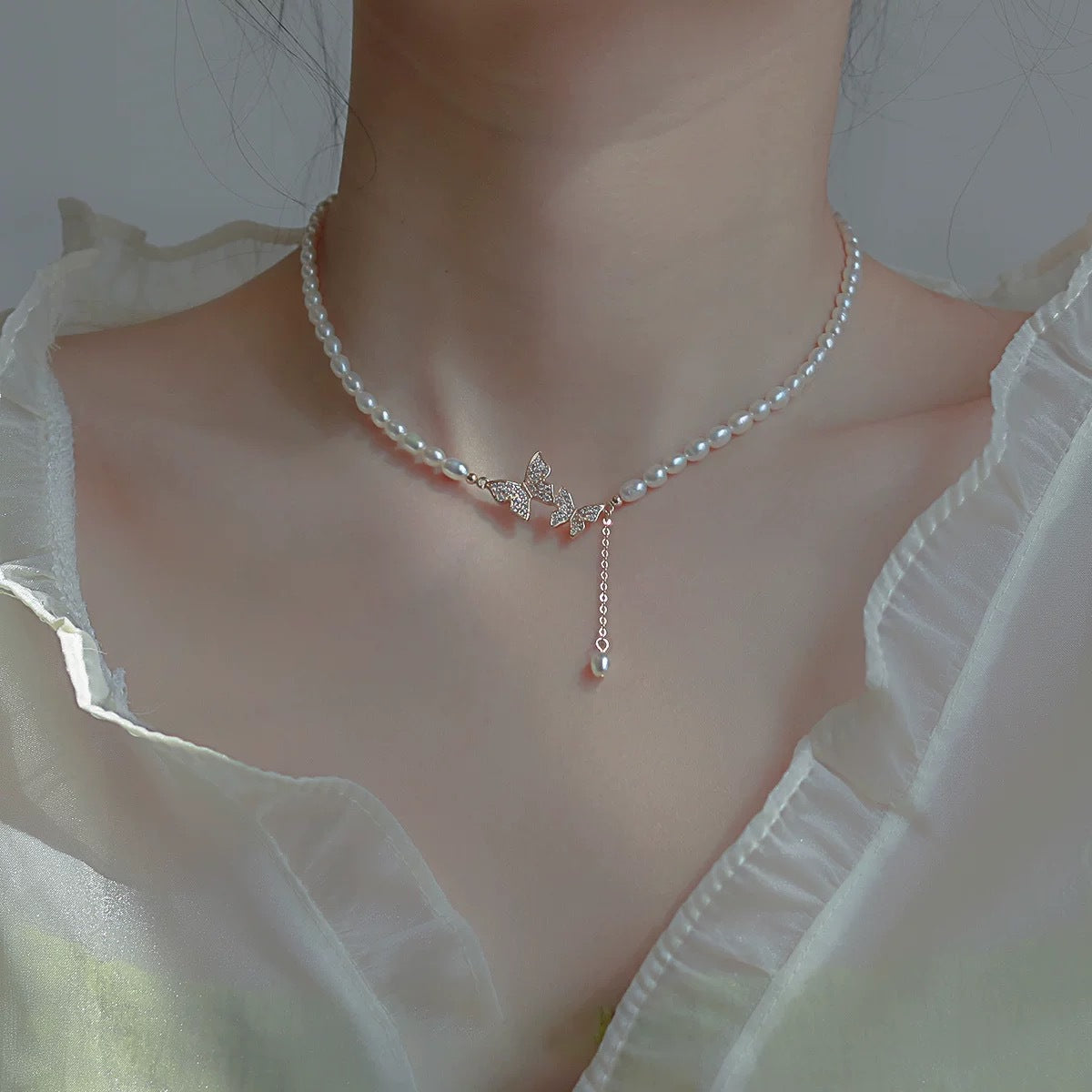 Damen Halskette mit filigranem Schmetterlingsanhänger und eleganten Süßwasserperlen Shop Nory