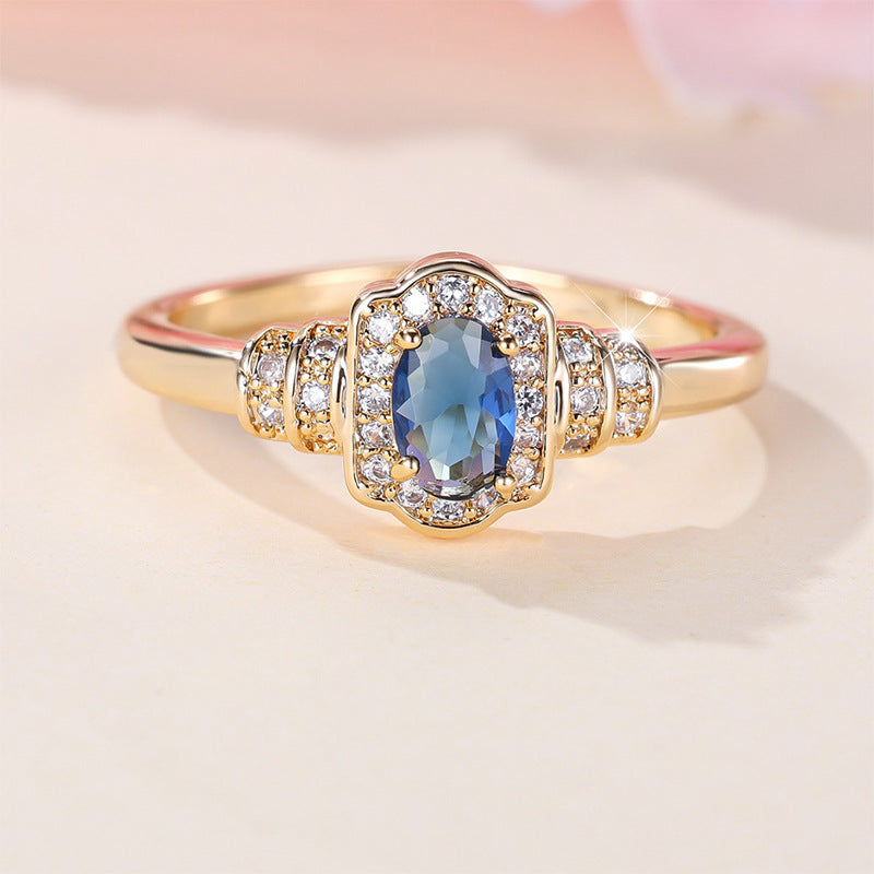 Damenring mit ovalem blauem Edelstein und funkelnden Zirkonia-Steinen Shop Nory