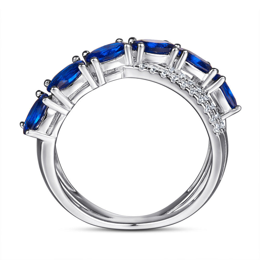 Damen Ring mit funkelnden blauen Zirkonia und eleganter, geschwungener Fassung Shop Nory