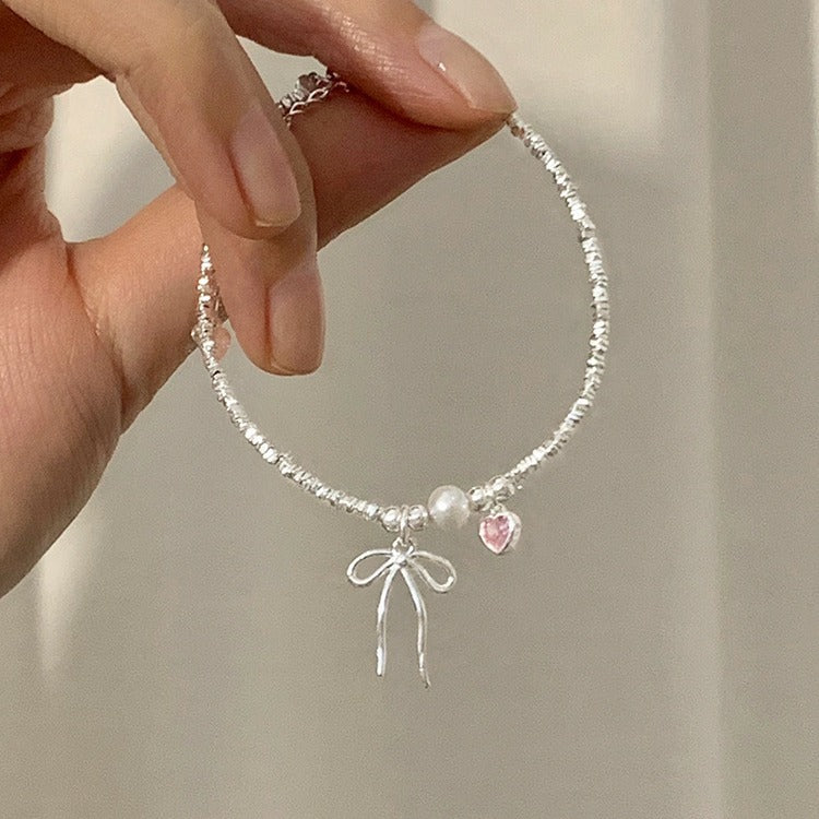 Damen Armreif mit Herz-, Perlen- und Schleifenanhänger Shop Nory