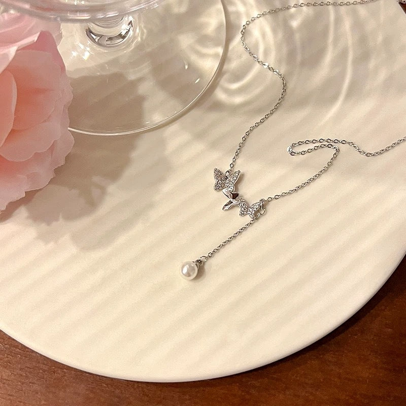 Damen Kette mit eleganten Schmetterlingsanhängern und zarten Perlendetails Shop Nory