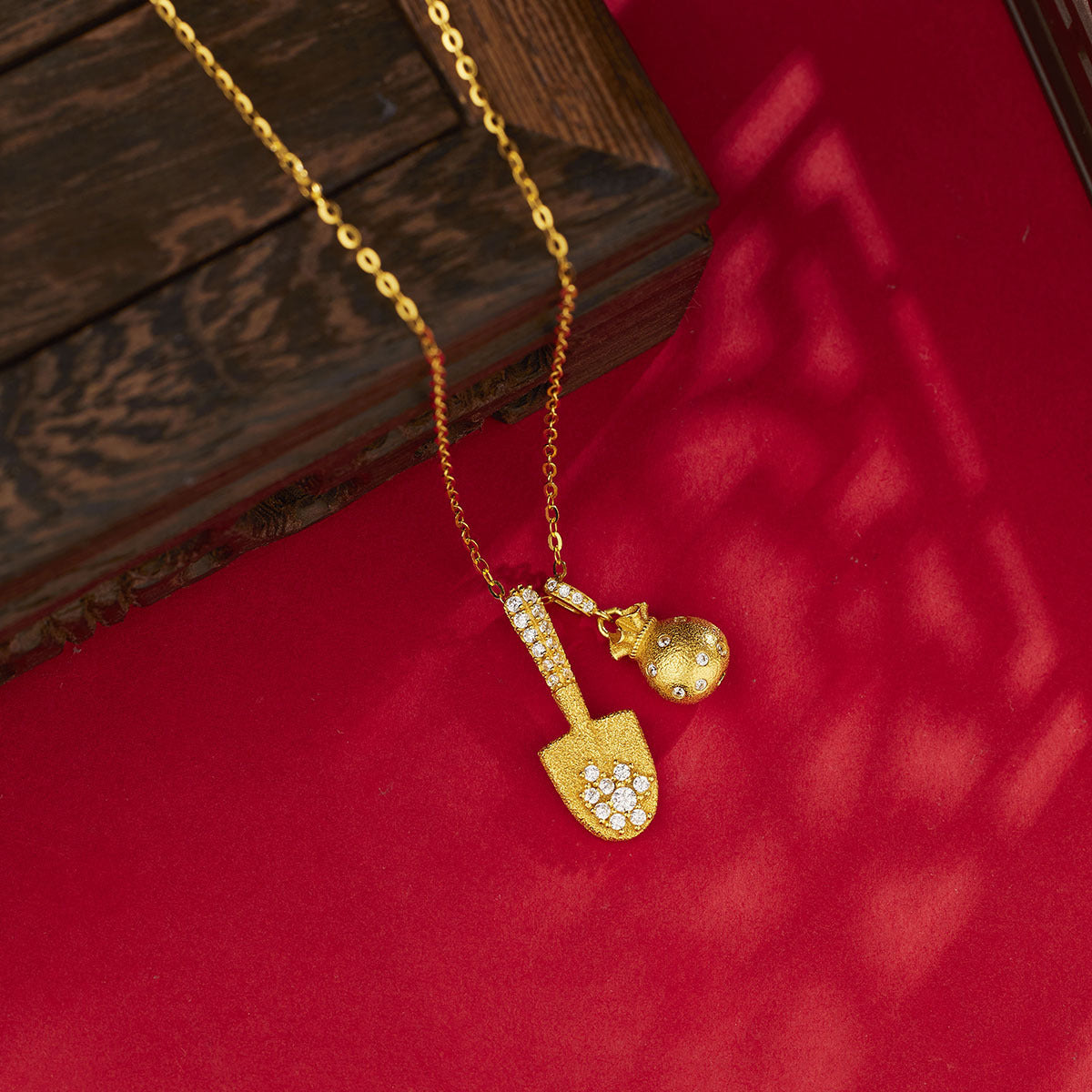 Damen Halskette mit goldfarbenem Schaufel- und Geldbeutel-Anhänger und funkelnden Kristallen Shop Nory
