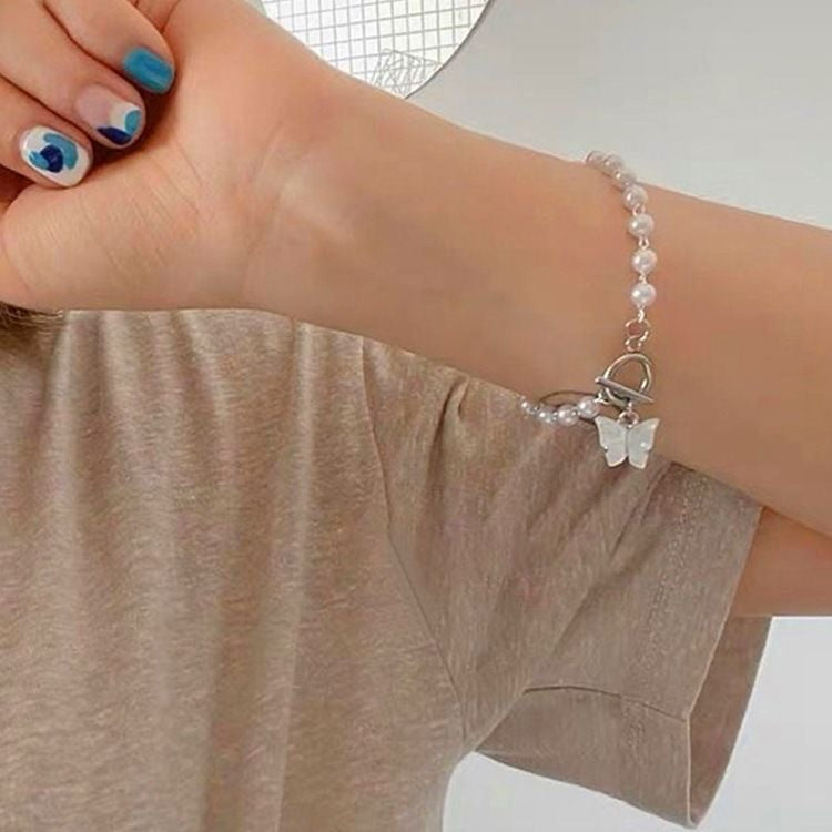 Damen Armband mit eleganten Süßwasserperlen und filigranem Schmetterlingsanhänger Shop Nory