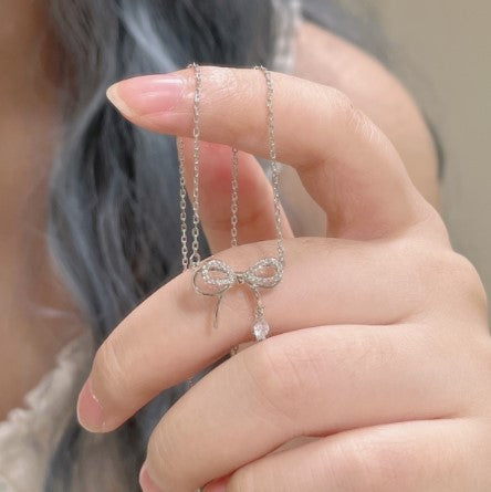 Damen Halskette mit filigranem Schleifenanhänger und funkelndem Zirkon Shop Nory