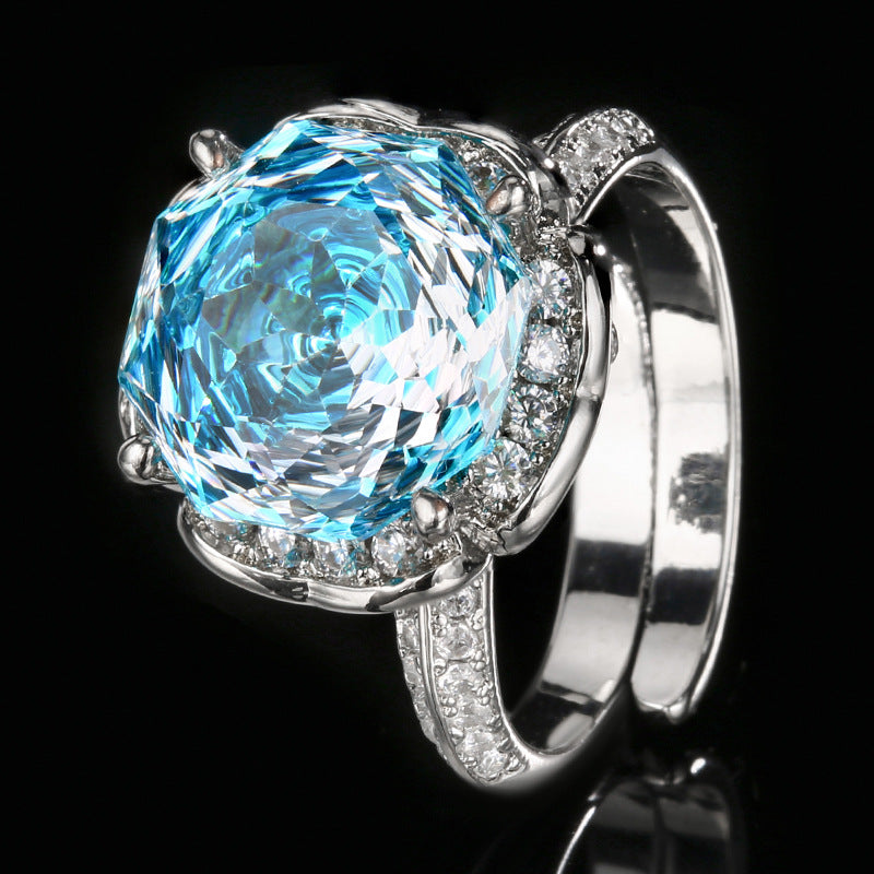 Luxuriöser Cocktailring aus Sterlingsilber mit Halo, großem facettiertem synthetischen Edelstein und Pavé-Band