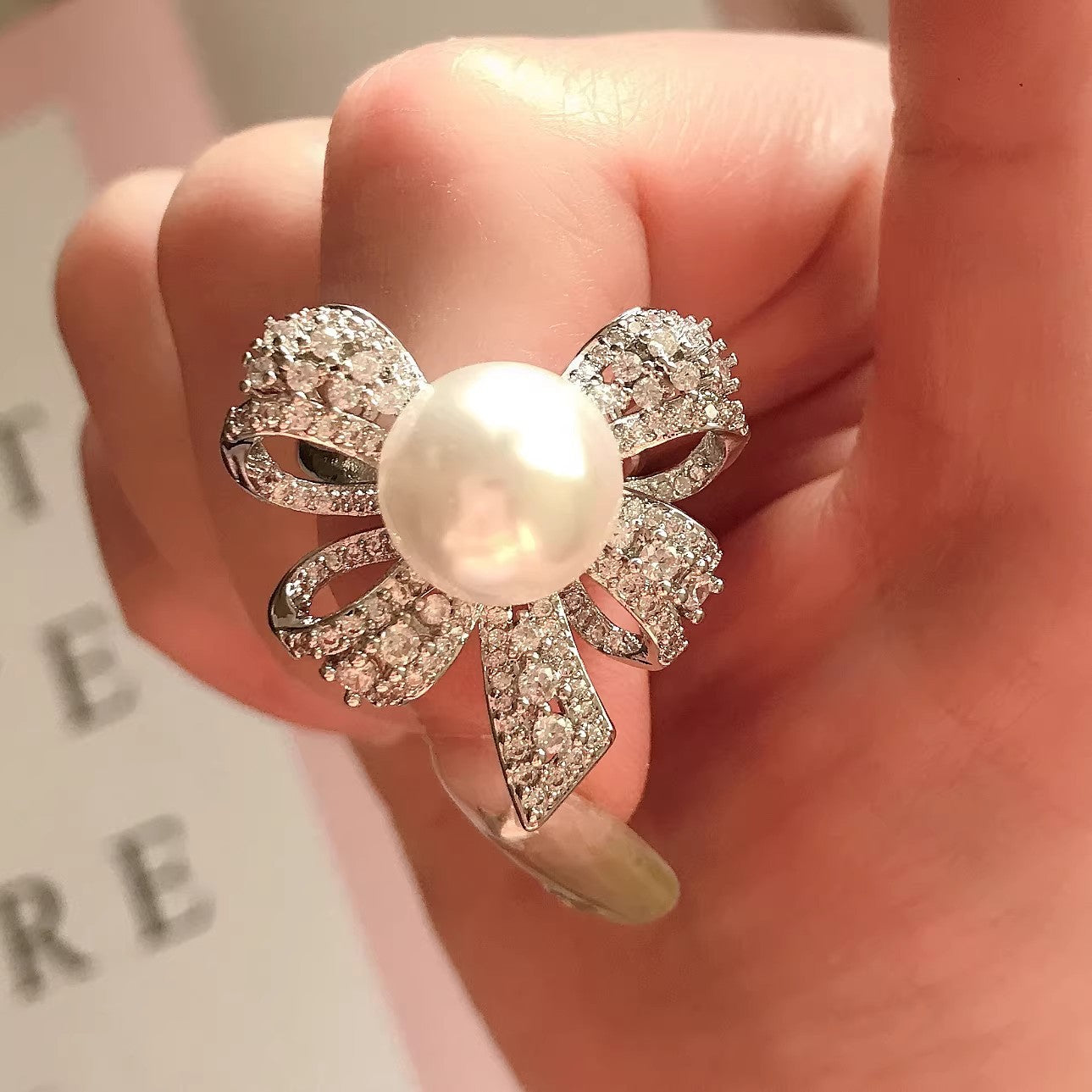 Damen Schmuckring mit elegantem Schleifenmotiv und strahlendem Perlenstein Shop Nory