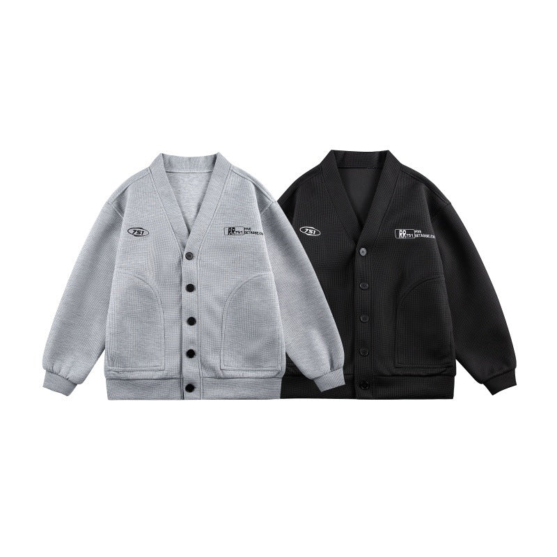 Unisex Boxy-Strickjacke im Waffelstrick mit V-Kragen, durchgehender Knopfleiste und aufgesetzten Rundtaschen Shop Nory