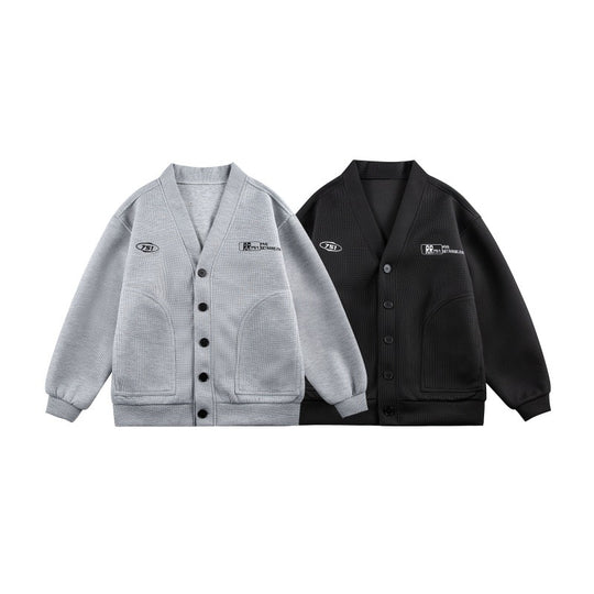 Unisex Boxy-Strickjacke im Waffelstrick mit V-Kragen, durchgehender Knopfleiste und aufgesetzten Rundtaschen Shop Nory
