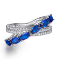 Damen Ring mit funkelnden blauen Zirkonia und eleganter, geschwungener Fassung Shop Nory