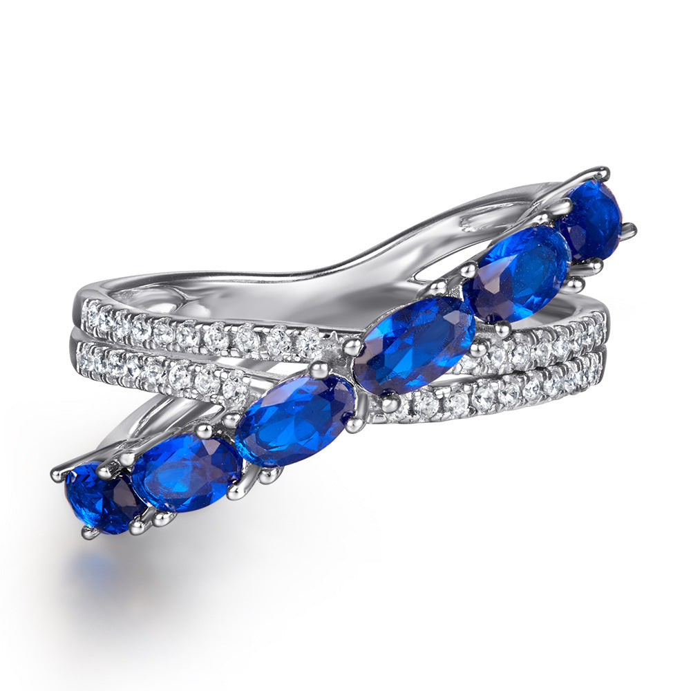 Damen Ring mit funkelnden blauen Zirkonia und eleganter, geschwungener Fassung Shop Nory