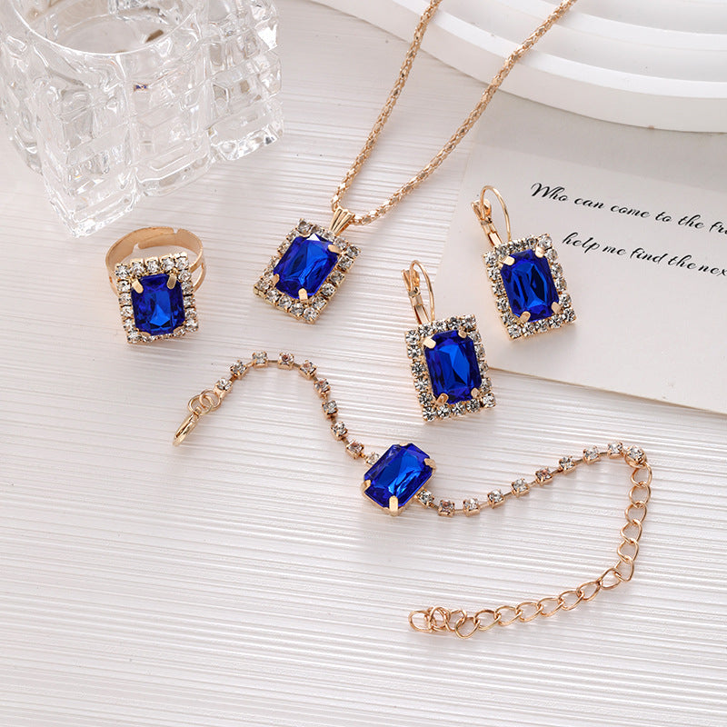 Luxuriöses Kristall-Statement-Schmuckset mit rechteckigem Halo-Anhänger, passenden hängenden Ohrringen, verstellbarem Tennisarmband und Statement-Cocktailring