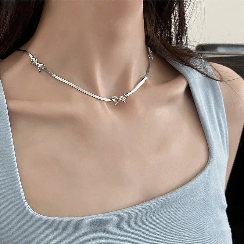 Damen Halskette mit geschwungenem Design und zartem Schleifenanhänger Shop Nory