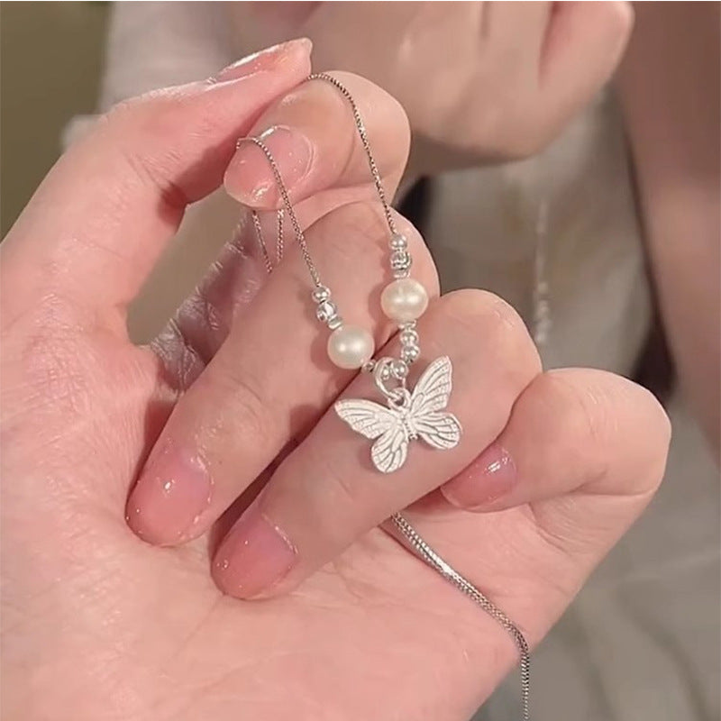 Damen Halskette mit kunstvollem Schmetterlingsanhänger und eleganten Perlenakzenten Shop Nory