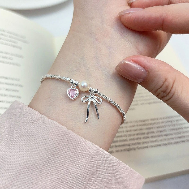 Damen Armreif mit Herz-, Perlen- und Schleifenanhänger Shop Nory