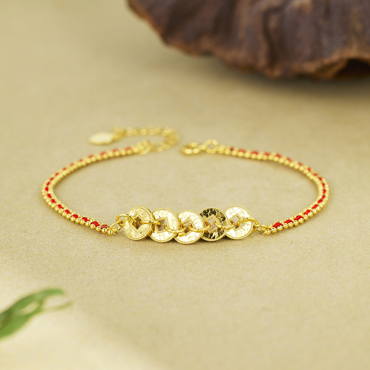 Damen kunstvolles Armband mit goldenem Münzdesign und roten Akzentperlen Shop Nory