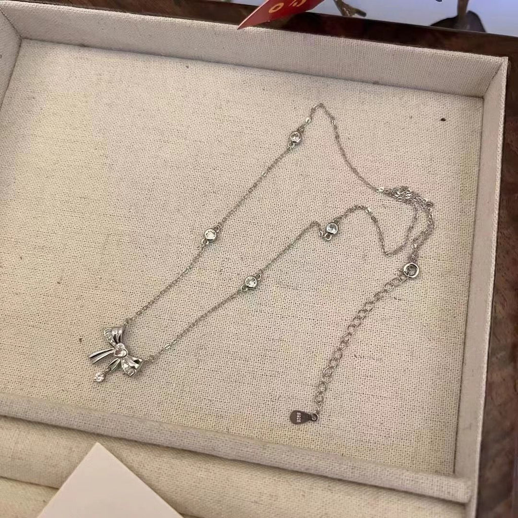 Damen Halskette mit elegantem Schleifenanhänger und funkelnden Kristallakzenten Shop Nory
