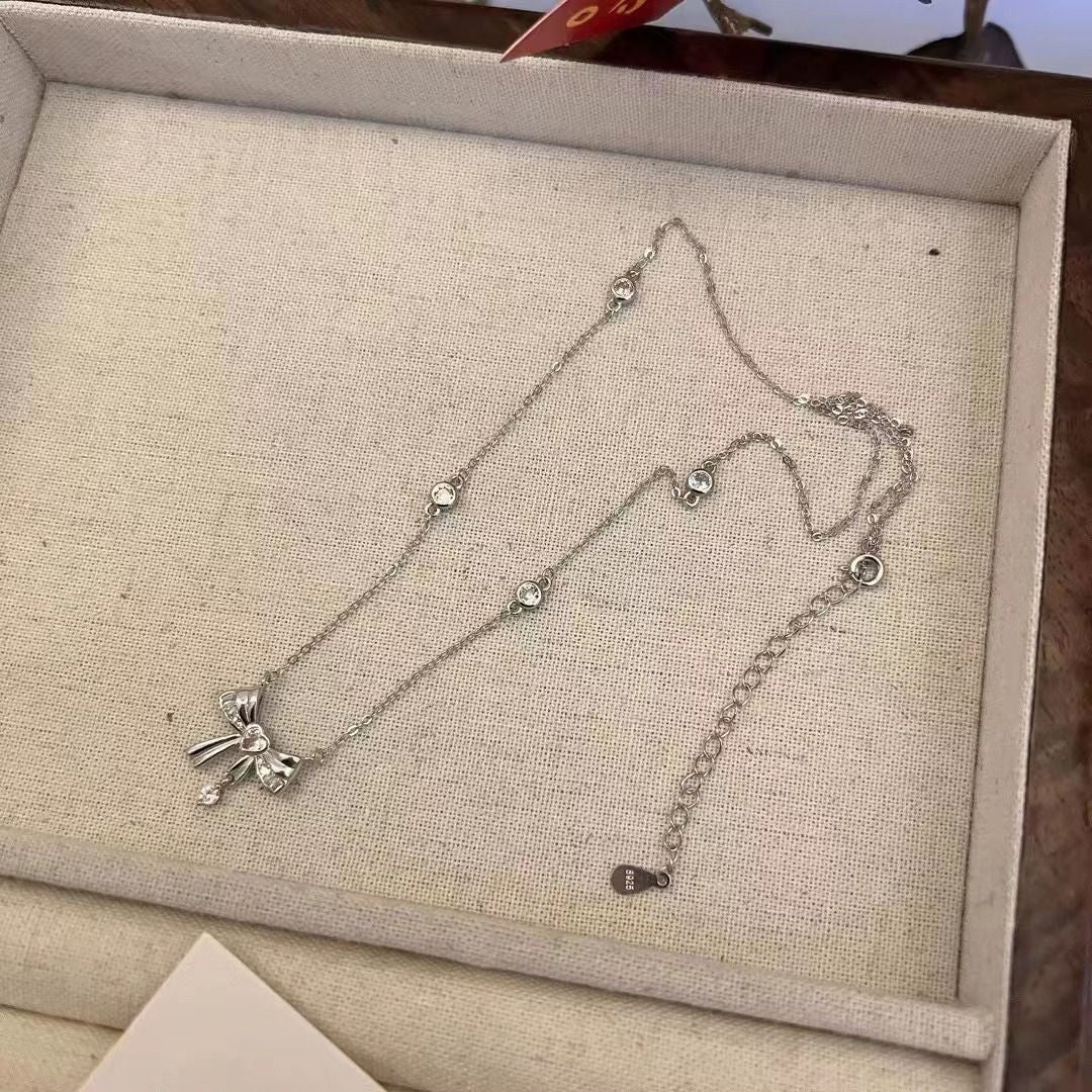 Damen Halskette mit elegantem Schleifenanhänger und funkelnden Kristallakzenten Shop Nory