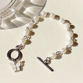 Damen Armband mit eleganten Süßwasserperlen und filigranem Schmetterlingsanhänger Shop Nory