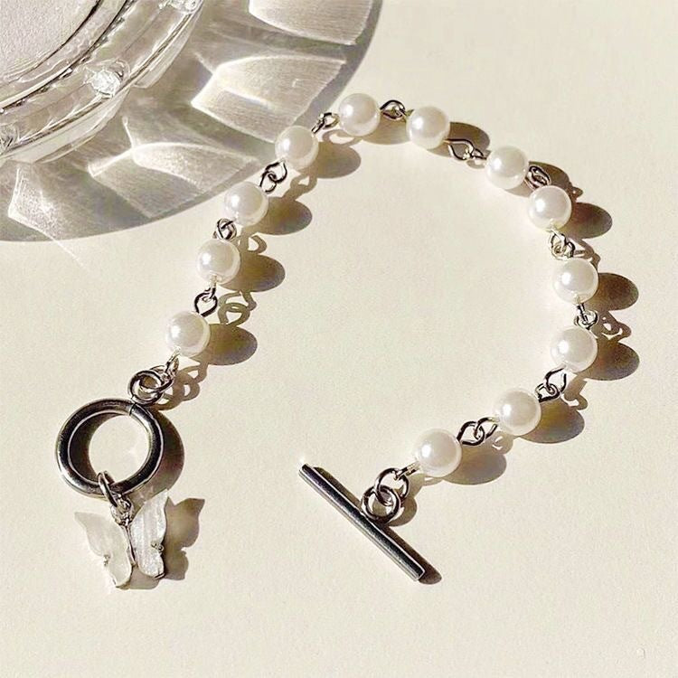 Damen Armband mit eleganten Süßwasserperlen und filigranem Schmetterlingsanhänger Shop Nory