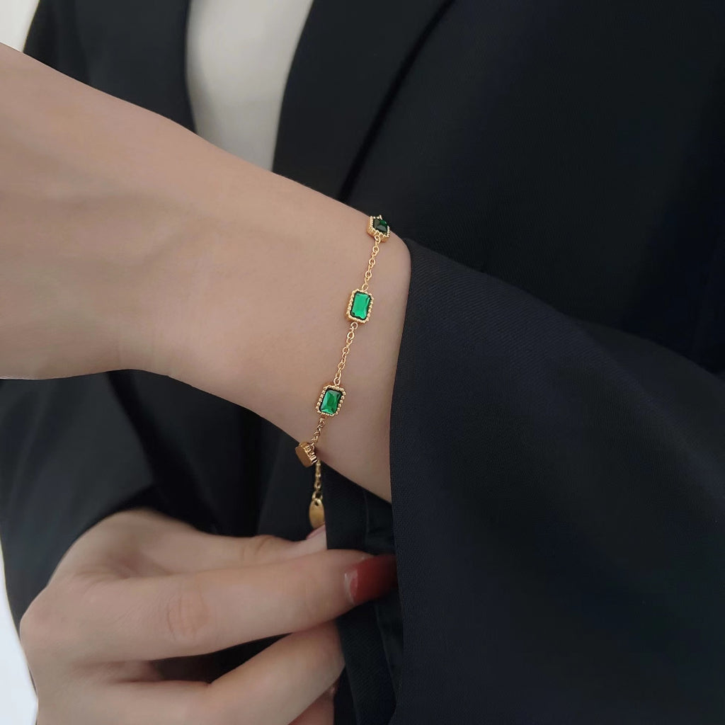 Damen Armband mit funkelnden grünen Steinen und hochwertiger Vergoldung Shop Nory