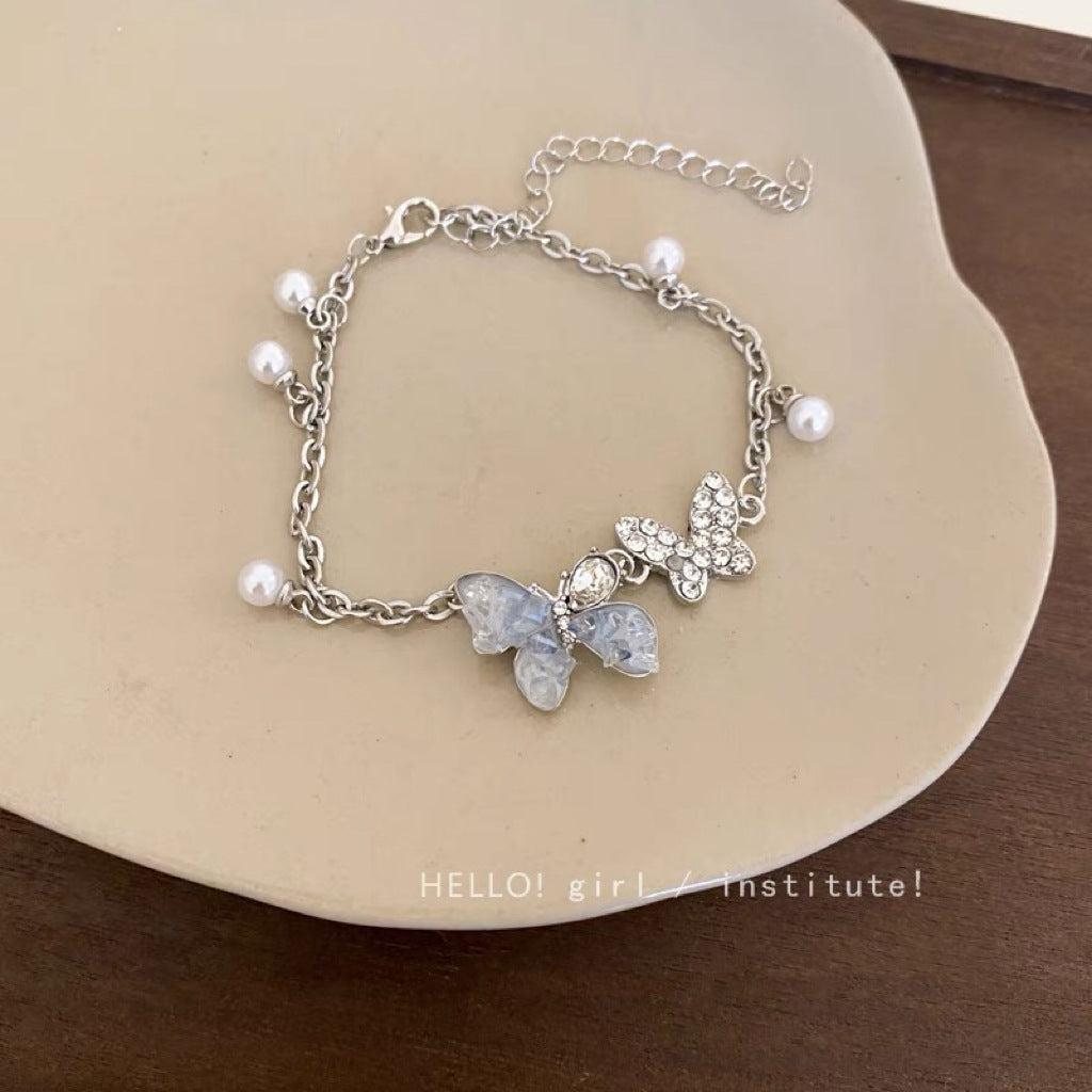 Damen Armband mit filigranen Schmetterlingsanhängern und eleganten Perlen Shop Nory