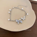 Damen Armband mit filigranen Schmetterlingsanhängern und eleganten Perlen Shop Nory