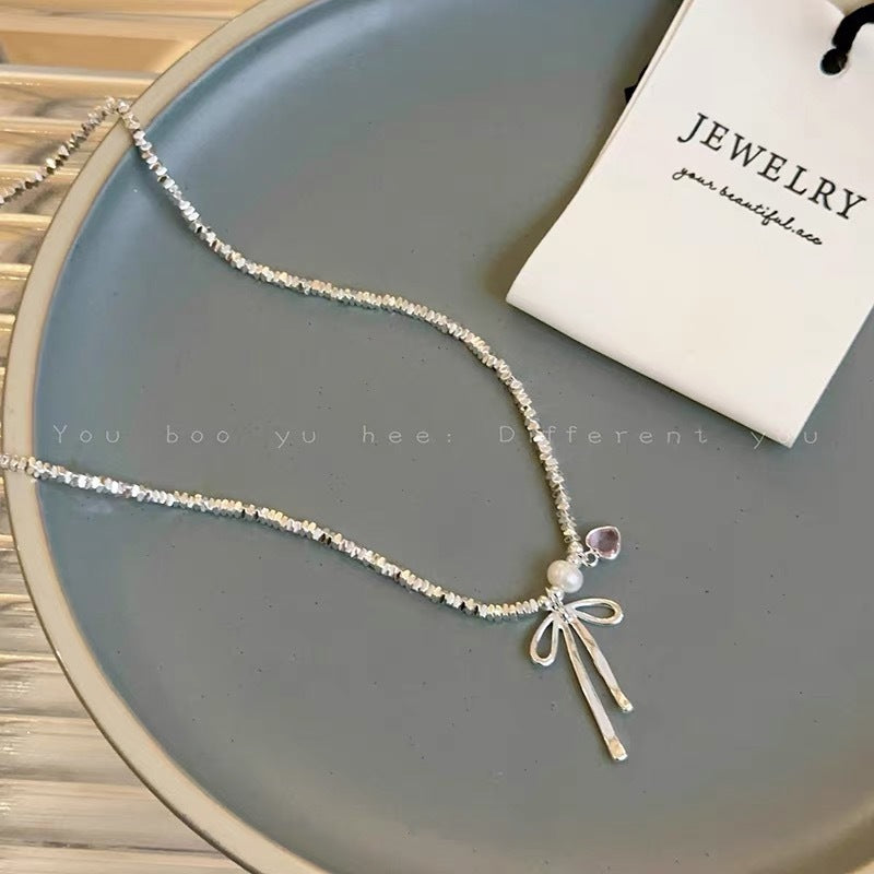 Damen Halskette mit zierlichem Schleifenanhänger und verspielten Perlen Shop Nory