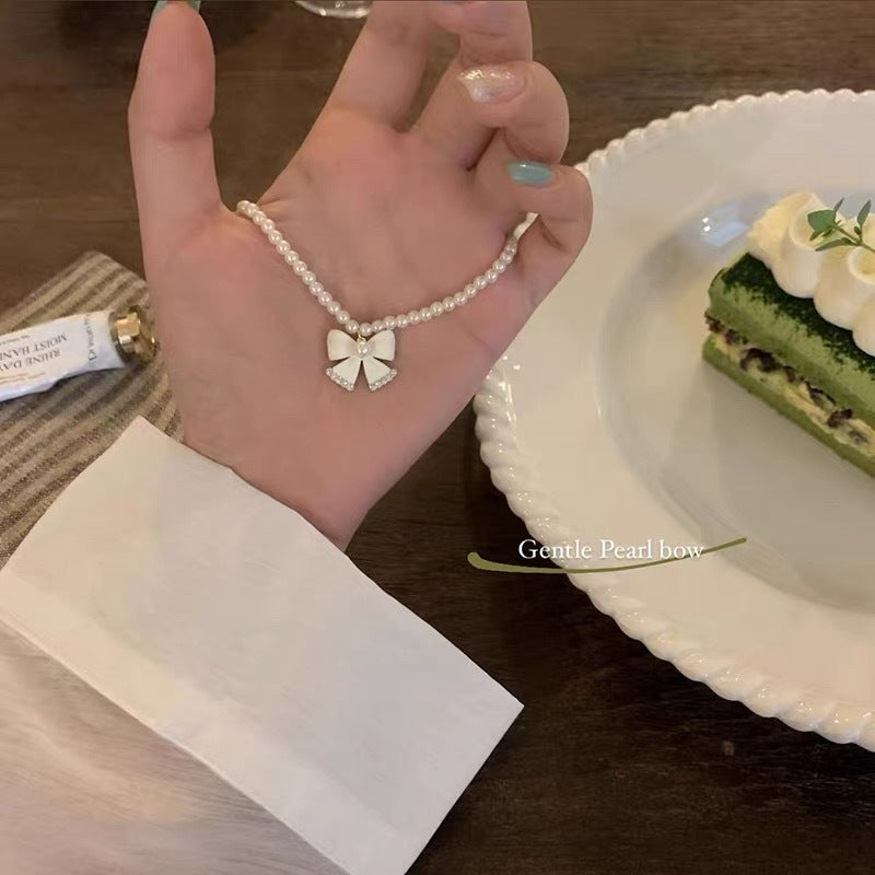 Damen Halskette mit elegantem Perlenband und filigranem Schleifenanhänger Shop Nory