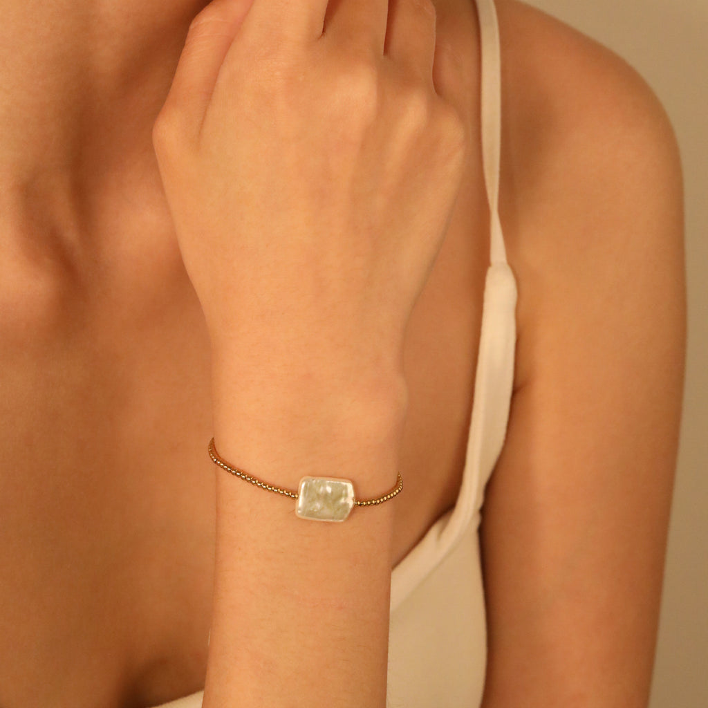 Damen Armband mit modernem Muschelanhänger und eleganten goldenen Akzenten Shop Nory